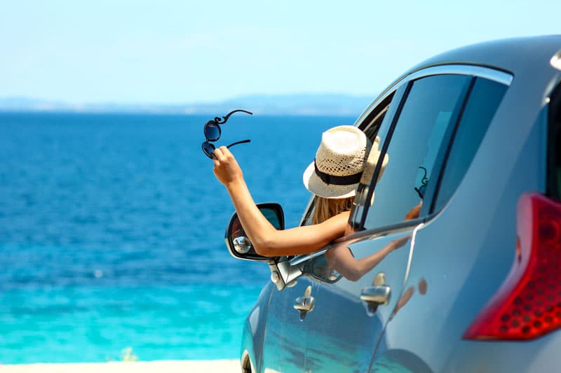 Femme qui est en vacances avec une voiture de location 