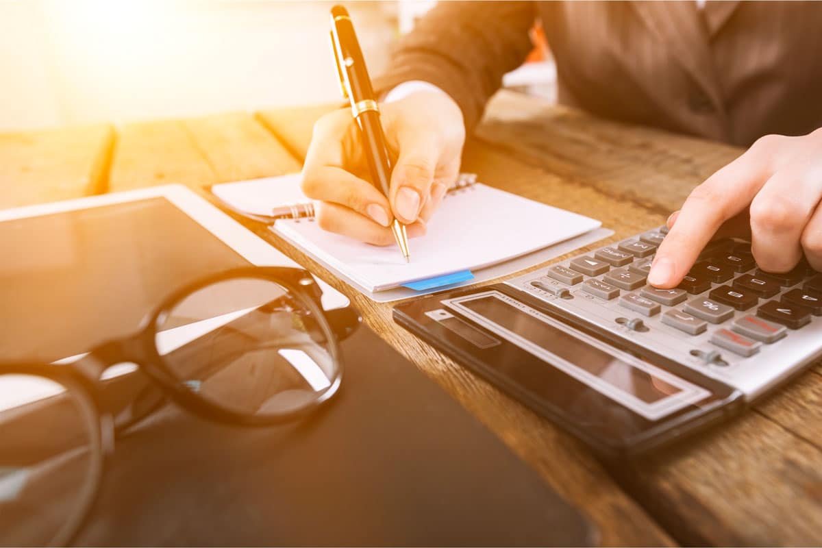 Personne qui utilise un carnet et une calculatrice