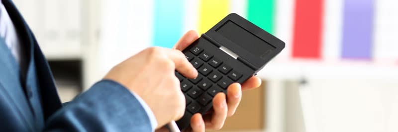 zoom sur une personne qui tient une calculatrice