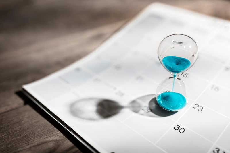 Zoom sur un calendrier et un sablier qui représentent le temps
