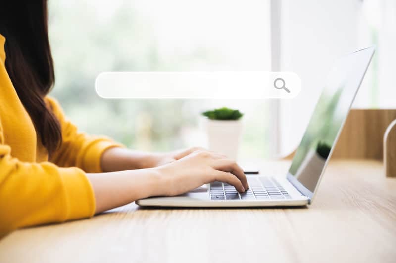 Femme qui utilise la barre de recherche de son ordinateur