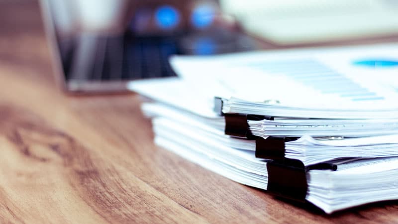 Pile de documents posés sur un bureau 