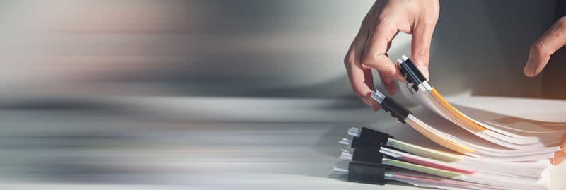Pile de documents papiers posées sur un bureau